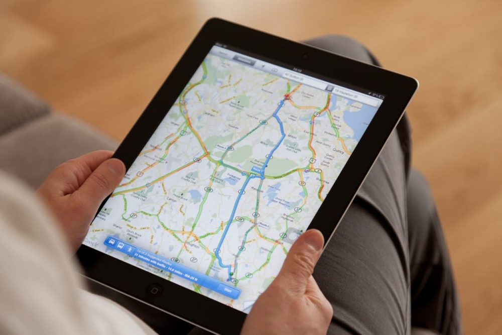 person holding tablet and using map feature