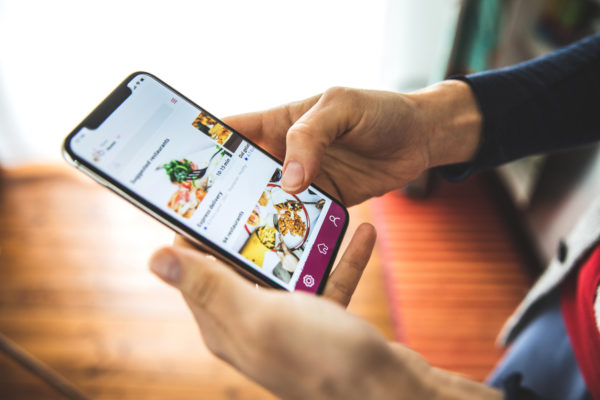 Woman using her mobile phone to access an application in searching for different products and business or store locations.